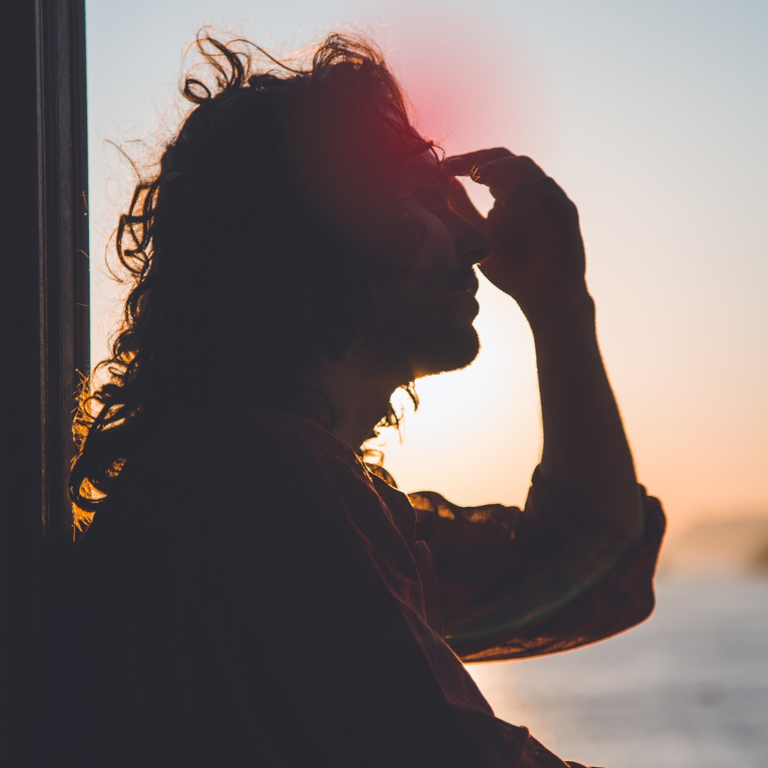 Woman holding her head because of chronic pain.