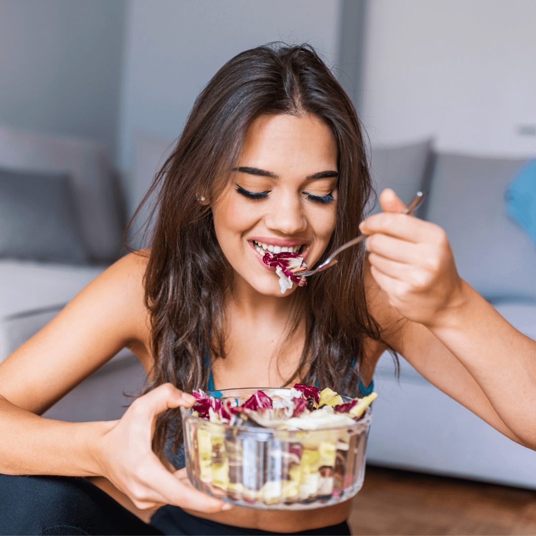 Young woman eating salad