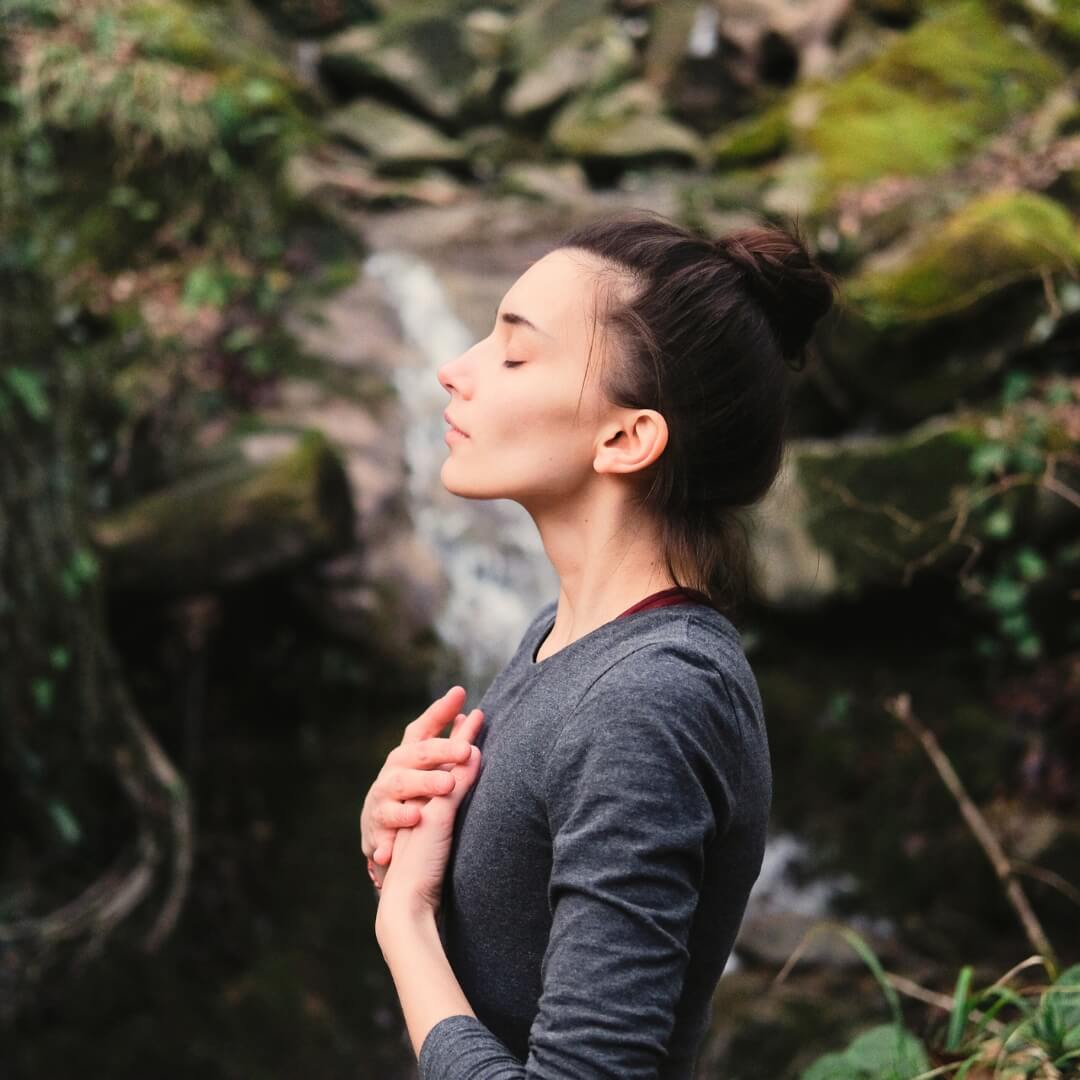 Woman relaxing next to a waterfall.