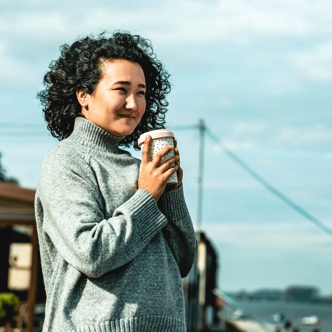 woman drinking coffee outside on a cold day