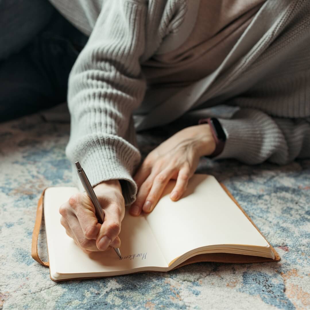 Person journaling in notebook.